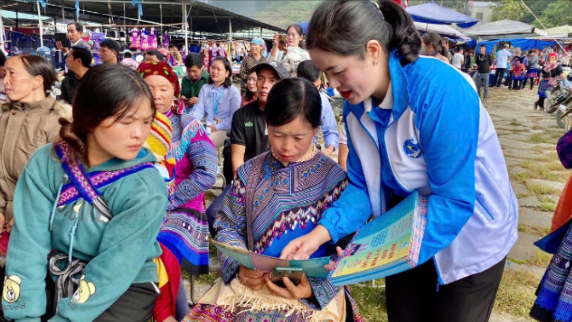 Phát tờ rơi tuyên truyền phòng, chống mua bán người tại chợ phiên Lùng Phình.(Ảnh báo Lào Cai)