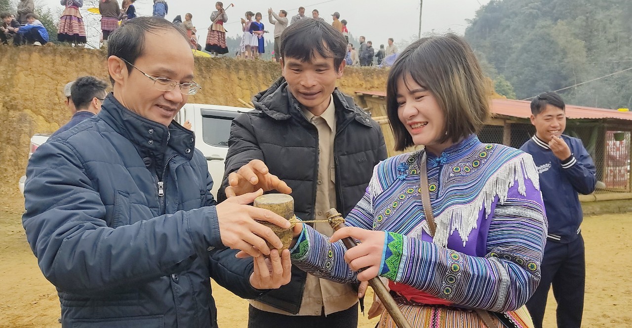 Khách du lịch trải nghiệm môn đánh quay của đồng bào dân tộc Mông.