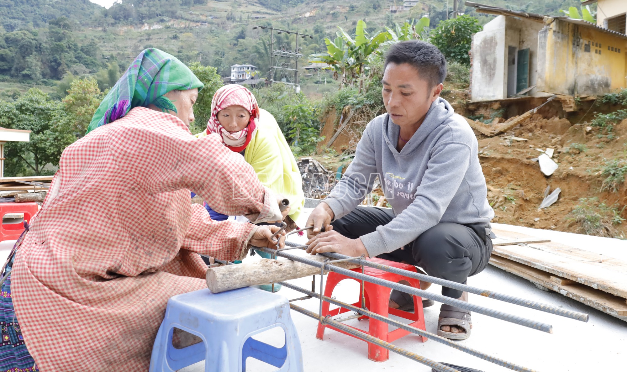 Giàng A Hỏa và người thân tích cực thi công nhà ở. Ảnh Báo Lào Cai 