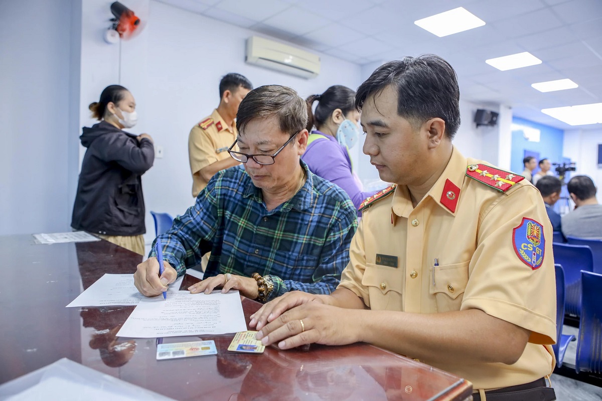 Lực lượng cảnh sát giao thông hướng dẫn công dân thực hiện thủ tục cấp đổi giấy phép lái xe. - Ảnh minh họa 