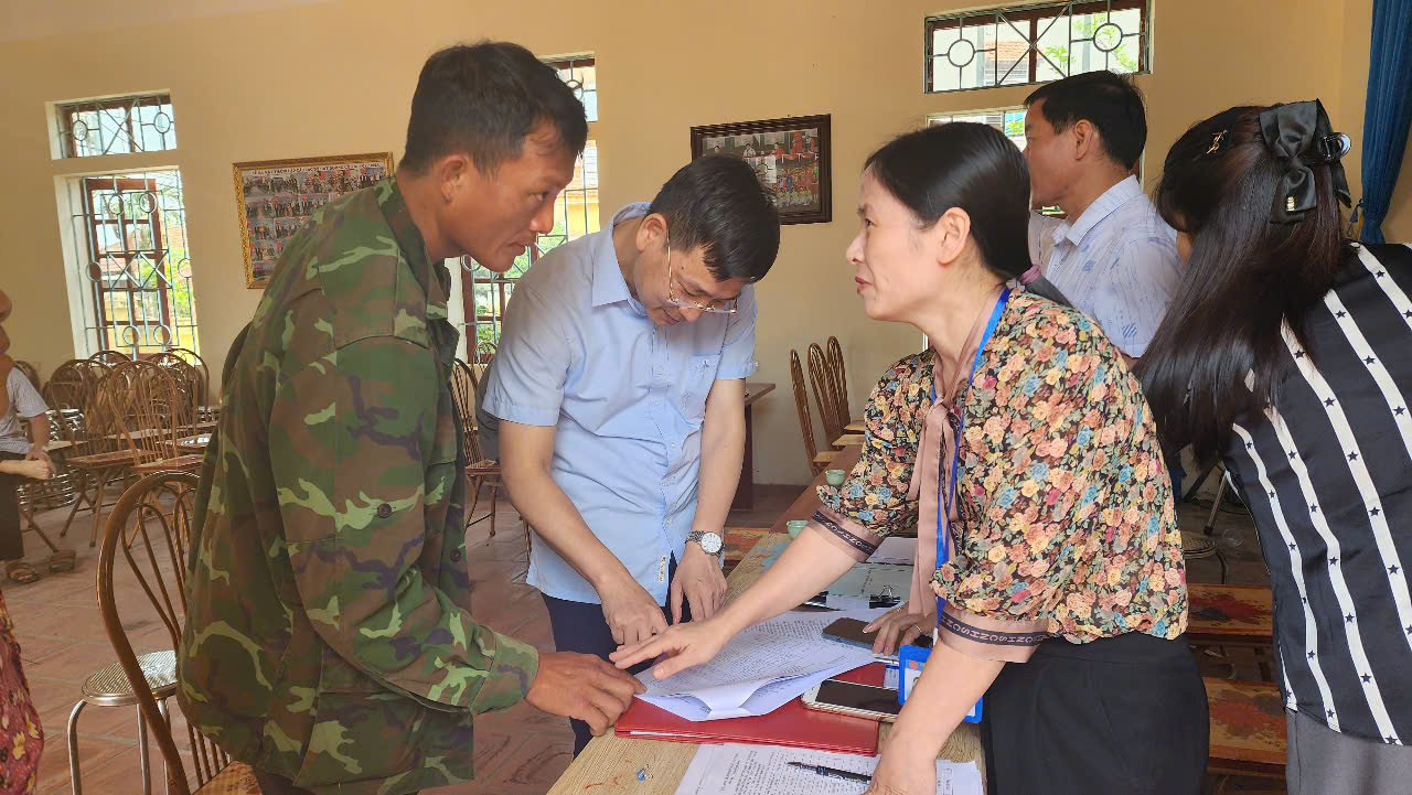 Ông Dương Văn Thắng, Bí thư Đảng uỷ xã Trung Mỹ cùng cán bộ của Ban QLDA Đầu tư xây dựng huyện Bình Xuyên hướng dẫn người dân làm thủ tục nhận tiền và trao đổi các vướng mắc để nhân dân hiểu rõ các mức chi trả.
