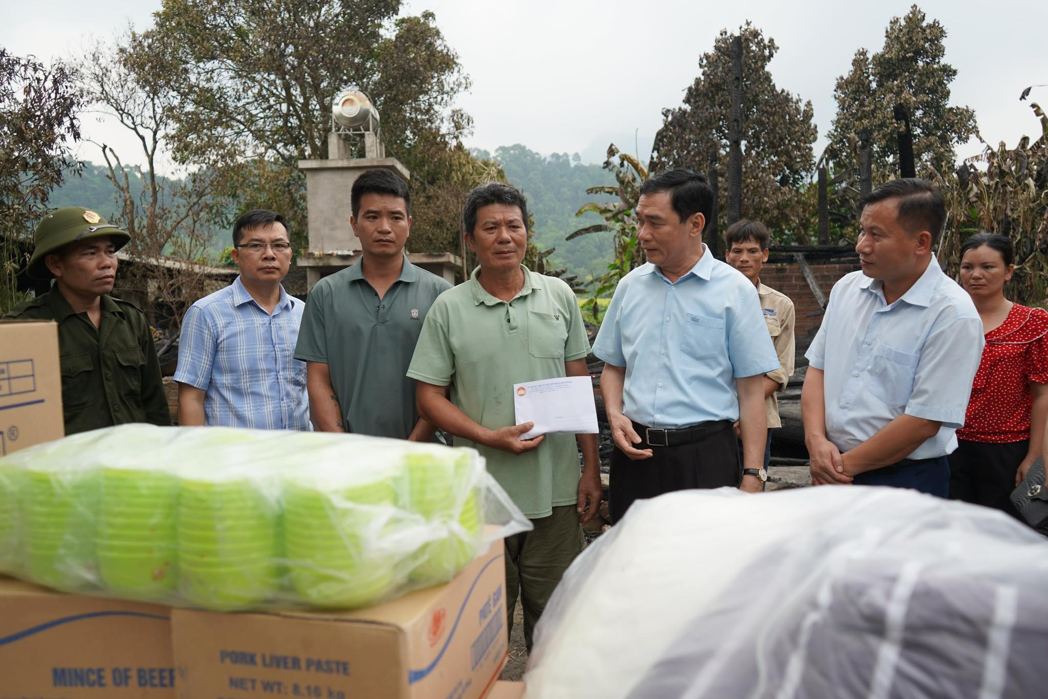Lanh dao huyen Van Ban trao tien cuu tro cho gia dinh ong Vi Van Tuong. 4567